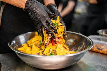 chef Cooking of crispy corn chips nachos at the restaurant kitchen