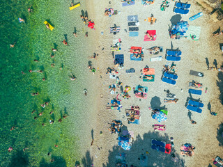 Aerial view of people relaxing at Gortanova beach, a narrow inlet with turquoise water, Pula, Istria, Croatia.