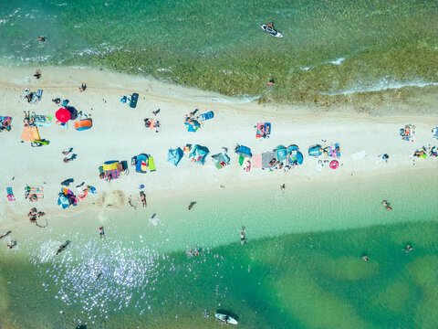 Aerial view of people relaxing at Emily Beach along the shoreline in summertime, Pula, Istria, Croatia.