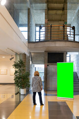 Woman inside a modern building looking at a custom roll up. Banner Mockup