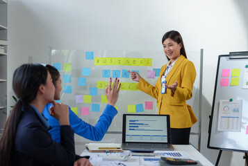 Group of colleagues, Asian businesswomen presenting and explaining investment project reports and planning strategies Budget calculation, business growth report on company laptop.