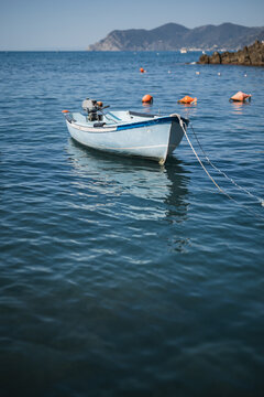 A small wooden boat with a motor in a quiet sea harbor - private transport for fishermen