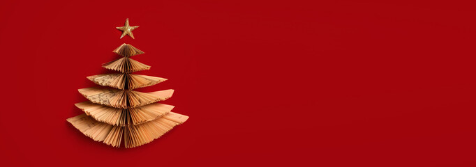 Christmas tree made from pile of books. Top view, flat lay, Colorful Books in form of christmas tree on red background. Creative minimalist Chirstmas background. Holiday book sale, Christmas reading.