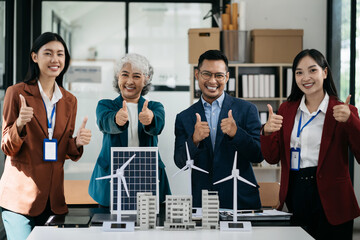 Successful Group of Young Asian business team giving victory thumbs up to show success and motivation.