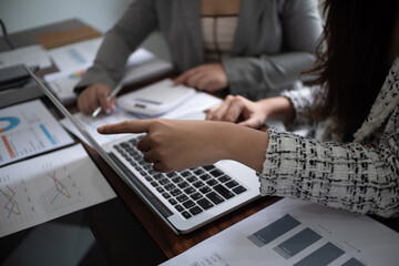 Cropped image of professional businesswoman, entrepreneur or accountant working on a financial report paperwork at her desk, using calculator or laptop