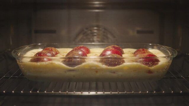 Plum pie in an oven preparation process. Slow motion