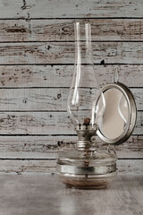 Old rusty gas lamp lit on vintage table 