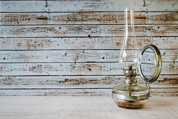 Old rusty gas lamp lit on vintage table 