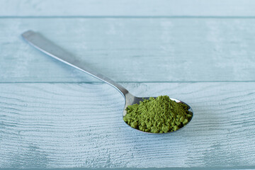 Matcha powder in a spoon on a table