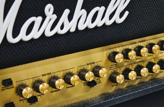 Close-up of a Marshall stack amplifier head showing the white logo on the grill mesh and rows of buttons