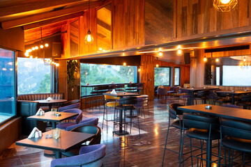 Interior of cozy restaurant with panoramic windows. Tables for four guests