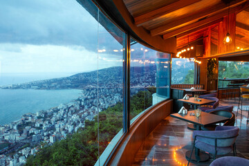Fototapeta na wymiar Interior of cozy restaurant with panoramic windows. Tables for four guests