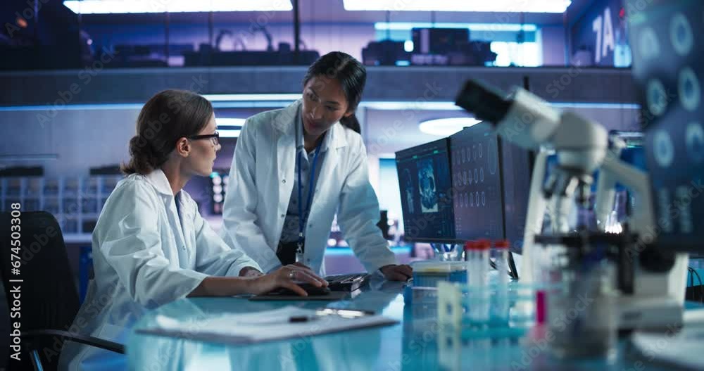 Poster asian and caucasian female doctors talking in medical research center and using desktop computer to 