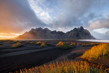 View over black beach in beautiful light with mount verstrahorn in background and dramatic sunset,...