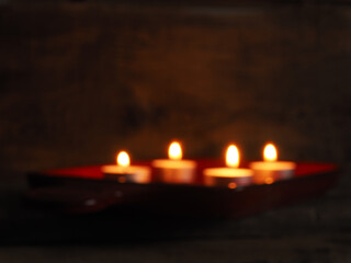 Blurry background of four Advent candles in a dark room