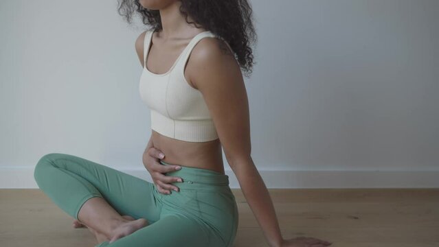 seated yoga breathing techniques with hand on the abdomen - close up