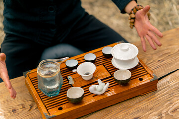 A set of special ceramic bowls and bowls is displayed on a wooden table with boiling water for tea ceremony