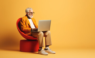 Aged Businessman sitting and working online job on computer or laptop. Creative idea with beige, orange and red color.