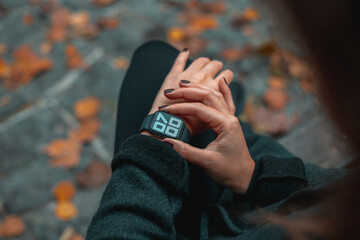 Young business woman checking the time on her watch. Smart watch display 7 AM