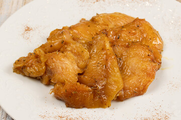 tranches de poulet cru et marinées, en gros plan, dans une assiette