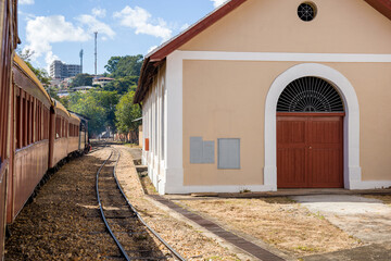Old train station in São João del Rei, via ferrea with train passing by