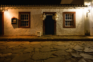 Facade of colonial houses at night in Tiradentes with fog apparent on the stone streets of the historic city, Minas Gerais, Brazil.