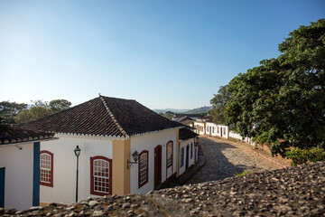 Fototapeta na wymiar Street with colonial houses in the city of Tiradentes in Minas Gerais with mountains in the background