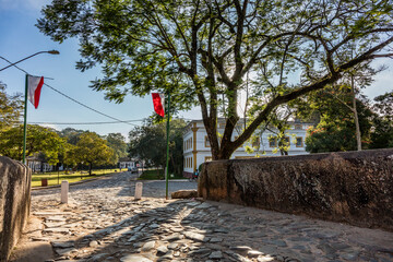 Bridge in Tiradentes with tree and sun shining, stone street in historic city in Brazil