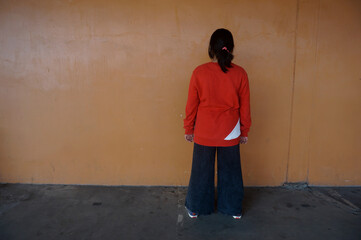 Little girl standing facing the wall. Autism and punishment concept