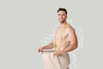 Muscled young man after weight loss on light background