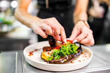 chef Cooking of grilled pork ribs with baked eggplant at the restaurant kitchen