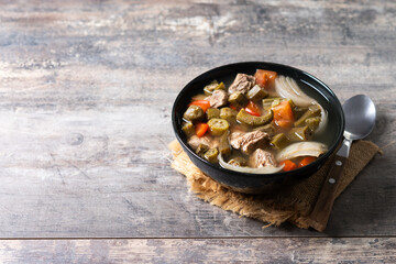 Traditional African okra soup on wooden table. Copy space