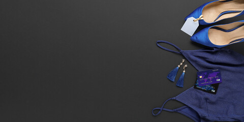 Stylish female clothes, shoes and credit cards on dark background with space for text. Black Friday sale