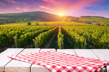 empty wooden table on the background of vines, tuscan landscape at sunrise. High quality photo