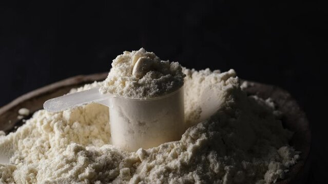 Scoop of dry whey protein signifies fitness, food, and sport.