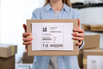 woman holding cardboard box with shipping label