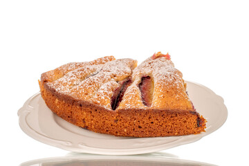 Sweet homemade pie with plums on a white ceramic saucer, macro, isolated on white background.