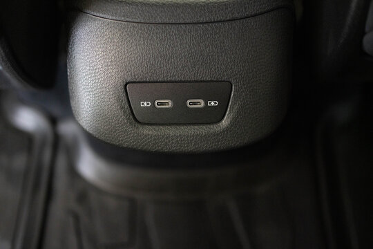 Panel in interior of a new electric car. Two USB C ports for the rear seats in a passenger car. Modern electric car usb socket for charging and accessories. Car interior.