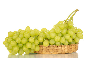 One bunch of sweet grapes on a straw plate, macro, isolated on white background.