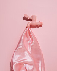 Faucet and satin cloth, creative aesthetic concept, flowing water, pastel pink composition.