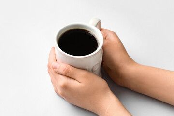 Woman holding cup of hot coffee on white background