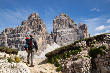 Fototapeta premium Stunning view of a tourist enjoying the view of the Tre Cime Di Lavaredo, Dolomites, Italy.