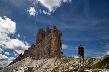 Stunning view of a tourist enjoying the view of the Tre Cime Di Lavaredo, Dolomites, Italy.