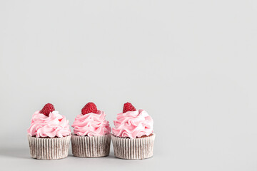 Tasty raspberry cupcakes on grey background - obrazy, fototapety, plakaty