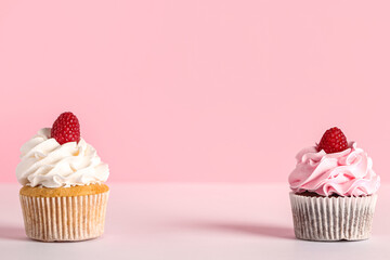 Tasty raspberry cupcakes on pink background