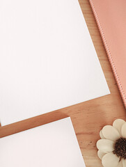 Top view sheet and notepad on desk, Empty White Sheet on Wooden Table - Flat lay mockup,  - flower, wood and pink - soft, cosy, boho ambiance