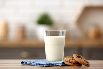 Glass of fresh milk with sweet cookies on wooden table in kitchen - Powered by Adobe