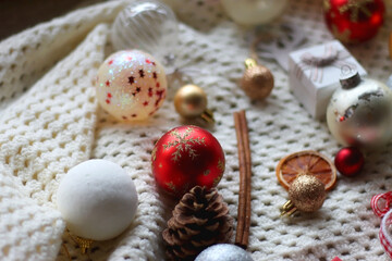 Various colorful Christmas ornaments, small presents and seasonal spices in a white box. Selective focus.