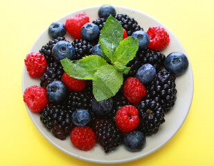 Raspberries, blackberries and blueberries in white bowl.