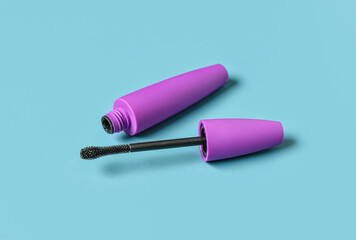 Black mascara in purple tube on blue background